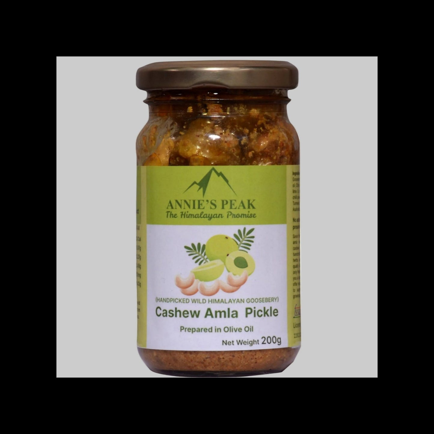 A 200g glass jar of Annie's Peak Cashew Amla Pickle, featuring a green and white label with illustrations of cashews and amla fruit, sealed with a brown metal lid.